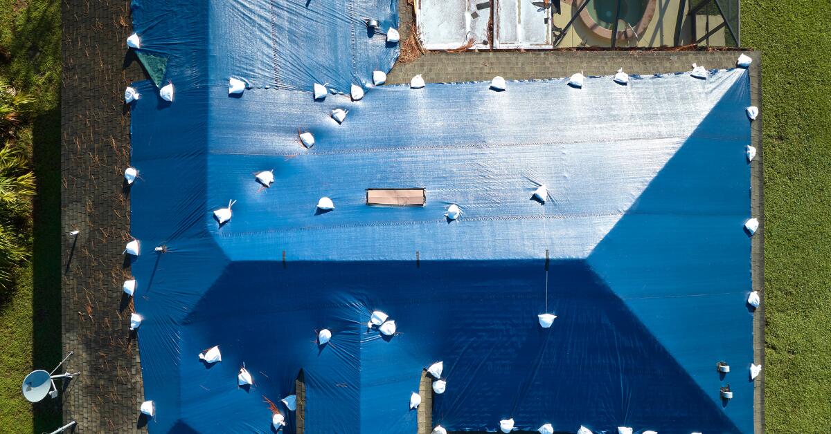 Image showing emergency roof tarping in Memphis during a storm.