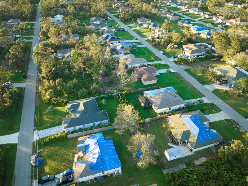 Image demonstrating emergency roof tarping in a large neighborhood.