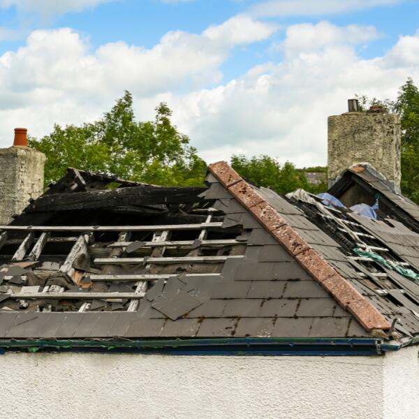 Picture of a roof with visible signs of extensive storm damage