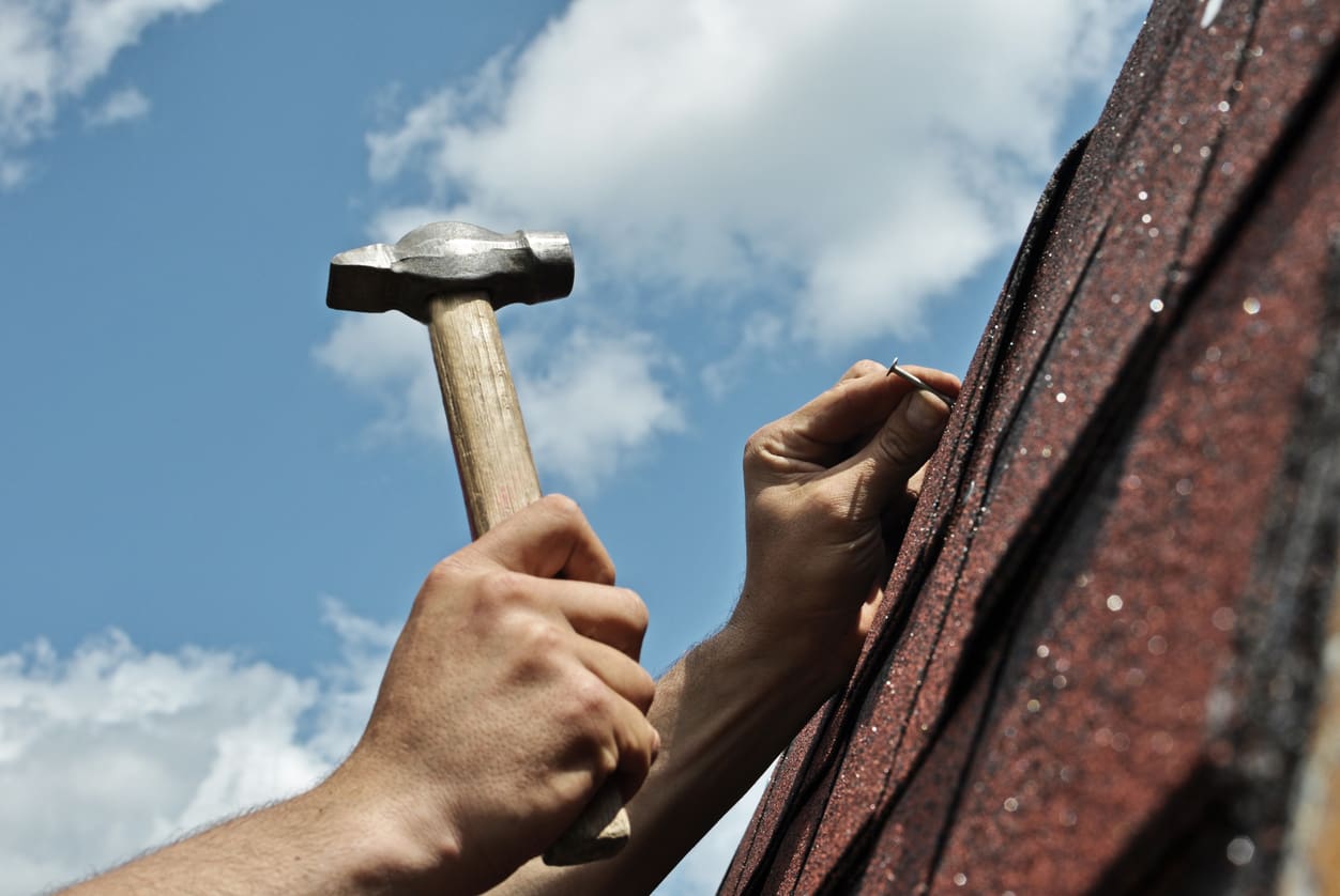 a person holding a hammer and nail